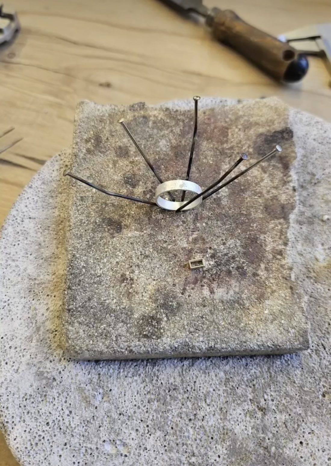 Zilveren ring op het soldeerblok, vastgezet met pinnen
